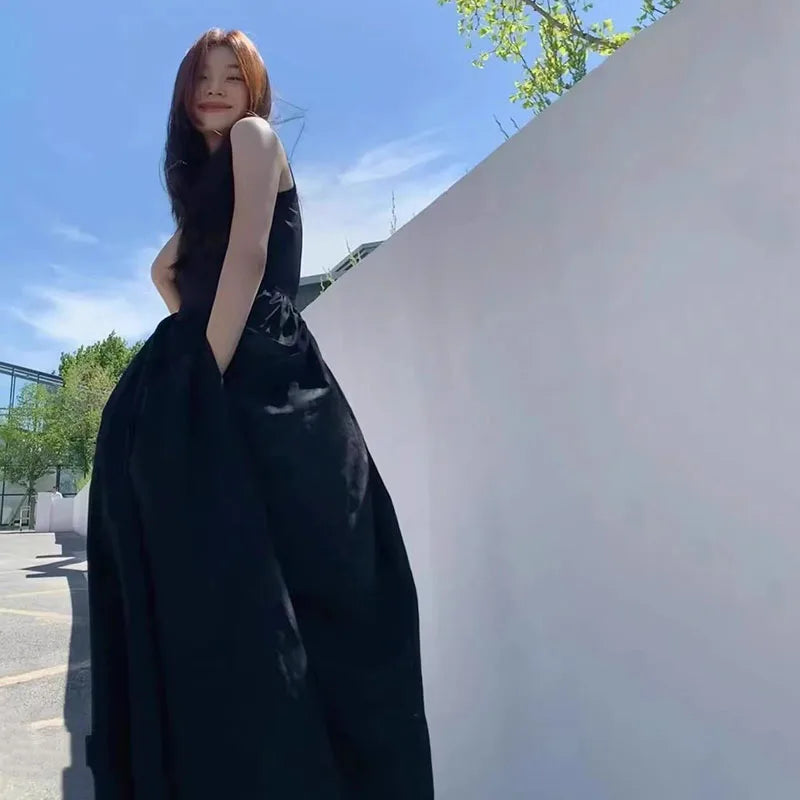 فستان ضيق أسود اللون مموج ويحيي، أنيق في ربيع ربيعي طويل. 